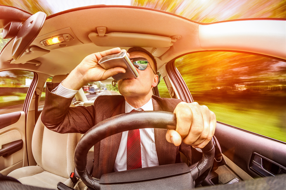 man drinking alcohol while driving
