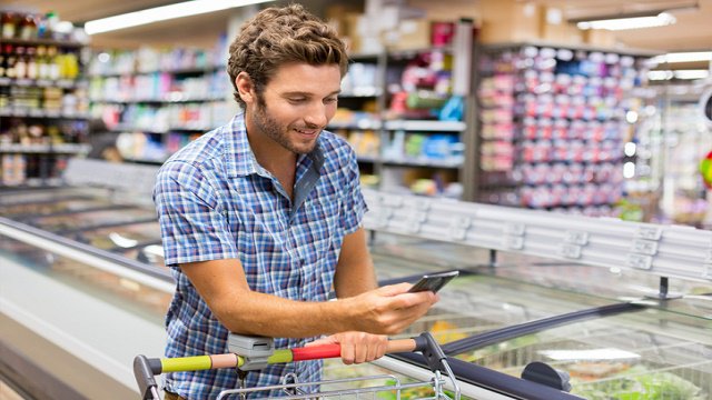 a man with a phone in a supermarket