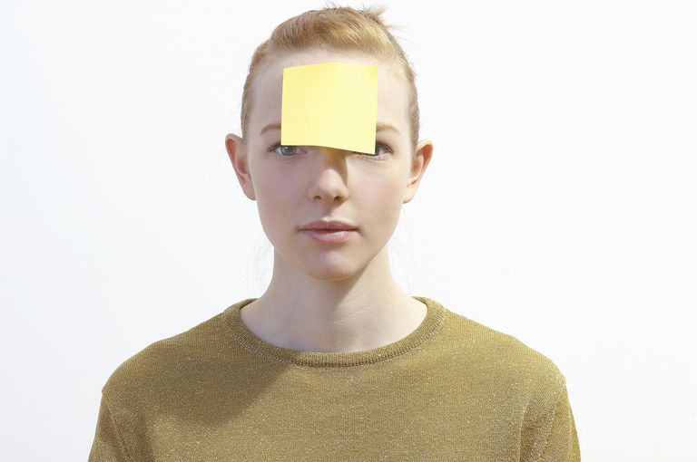 man with a note pasted on his forehead